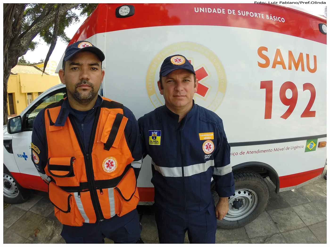 Dois socorristas do SAMU 192 em frente a uma ambulância de suporte básico
